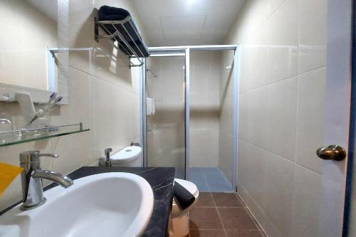 een badkamer met een wastafel en een douche bij D'Merlion Hotel in Bagam