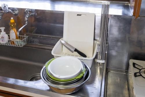 a pile of dishes sitting in a kitchen sink at Kujukuri Town Katakai Detached House in Katakai