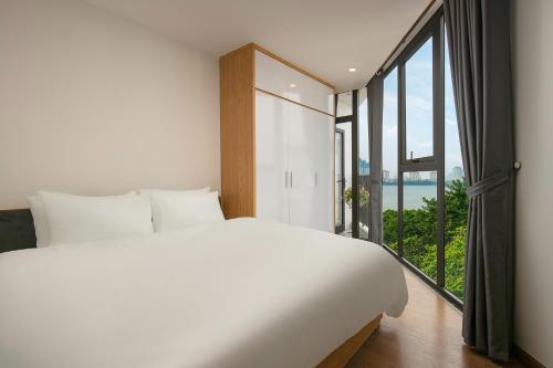 a bedroom with a large bed and a large window at Westlake Pearl Apartment - Hotel & Pearl Spa in Hanoi