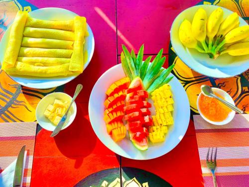 a table topped with plates of fruits and vegetables at Gangula Villa in Kandy