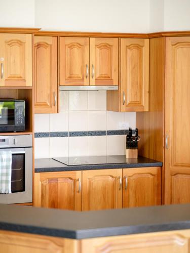 a kitchen with wooden cabinets and a black counter top at The Heights in Mannum
