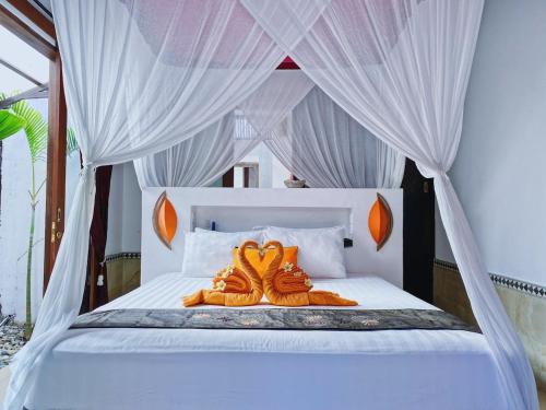 two pairs of shoes sitting on top of a bed at Villa Asyik in Seminyak