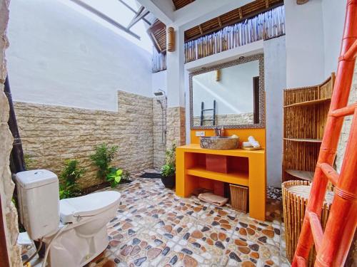 a bathroom with a toilet and a mirror at Villa Asyik in Seminyak