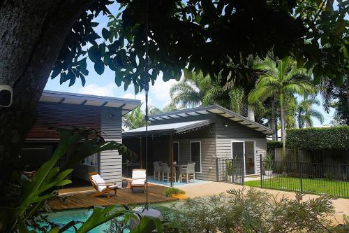 a house with a deck and chairs in front of it at Pantai Indah Villa in Torquay
