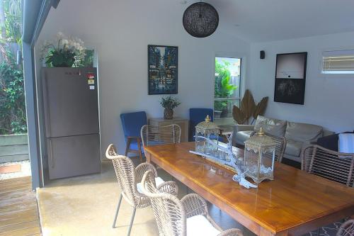 a living room with a wooden table and chairs at Pantai Indah Villa in Torquay