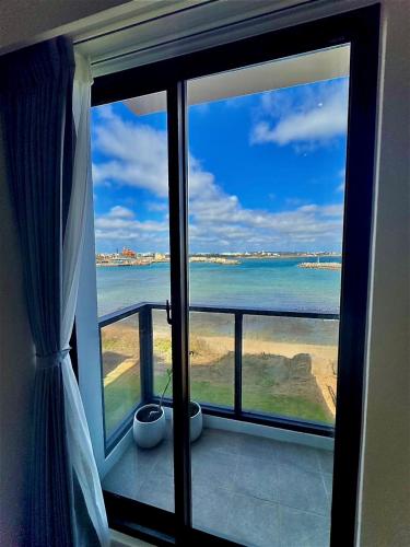 a room with a view of the ocean from a window at Tidal Stream Sea View B&B in Magong