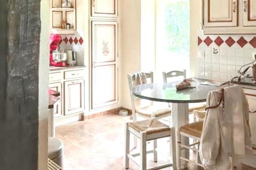 une cuisine avec une table et des chaises dans une pièce dans l'établissement Maison normande apaisante à Hermival-les-Vaux avec sauna, à Hermival-les-Vaux
