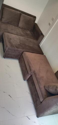 a brown couch sitting on the floor in a room at VicaWorld in Prathai