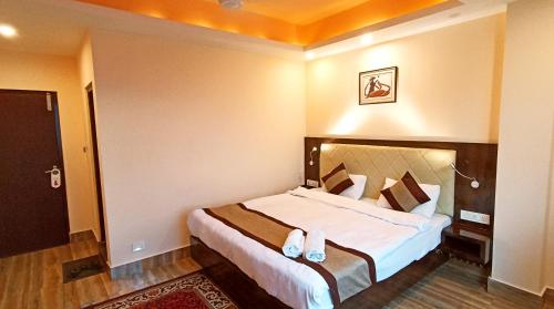 a hotel room with a bed with slippers on it at Garden Retreat Hotel in Gangtok