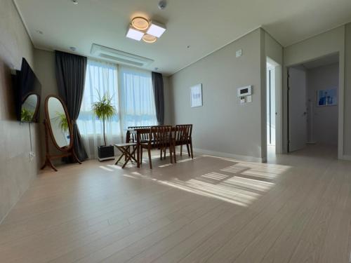 a living room with a table and chairs in it at Eunhasu D&M Residence in Daejeon