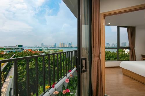 a bedroom with a balcony with a view of the city at Westlake Pearl Apartment - Hotel & Pearl Spa in Hanoi