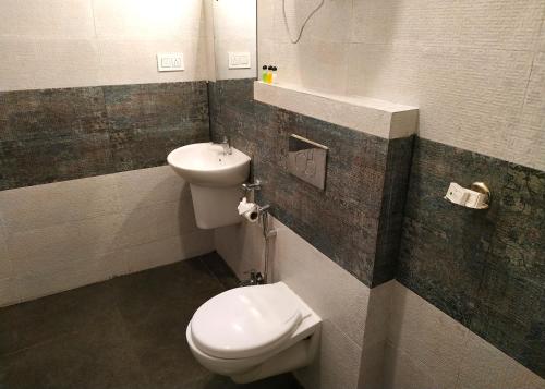 a bathroom with a toilet and a sink at Garden Retreat Hotel in Gangtok