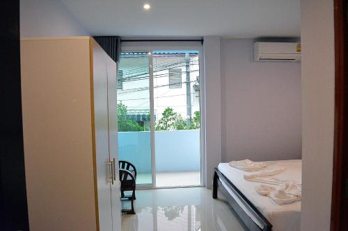 ein Schlafzimmer mit einem Bett, einem Stuhl und einem Fenster in der Unterkunft zzeehouse in Ao Nang Beach