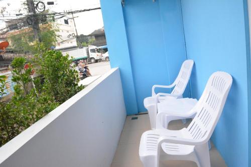 two white chairs sitting on top of a balcony at zzeehouse in Ao Nang Beach