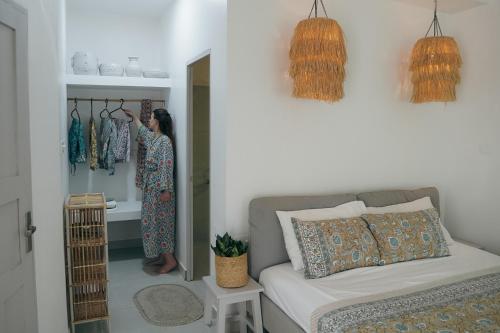 a woman in a room with a couch and some clothes at Utopia Varkala - Boutique stay in Odayam rice fields in Varkala