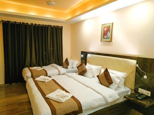 a hotel room with two beds with towels on them at Garden Retreat Hotel in Gangtok
