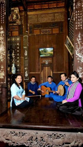 a painting of a group of people playing instruments at Út Bình Homestay in Vĩnh Long