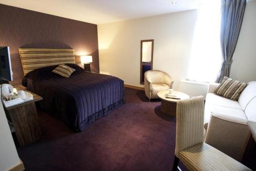 um quarto de hotel com uma cama e um sofá em Albert Hotel em Kirkwall