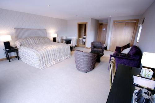 Habitación de hotel con cama y sala de estar. en Albert Hotel en Kirkwall