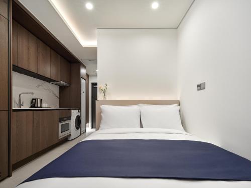 a bedroom with a large bed and a microwave at Hotel The Botanik Sewoon Myeongdong in Seoul