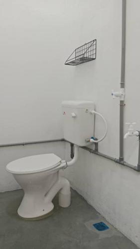 a bathroom with a white toilet in a room at One Mek Bilik Single in Kampong Jelutong
