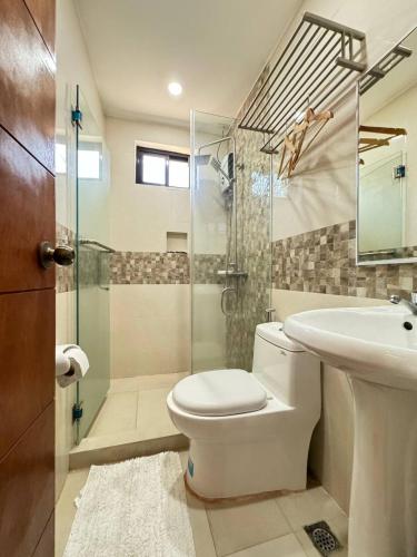 a bathroom with a toilet and a sink and a shower at Dy Heritage Suites in Vigan