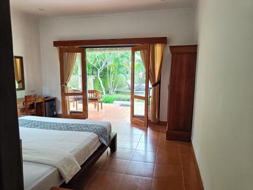 a bedroom with a bed and a sliding glass door at Giri Carik in Sidemen