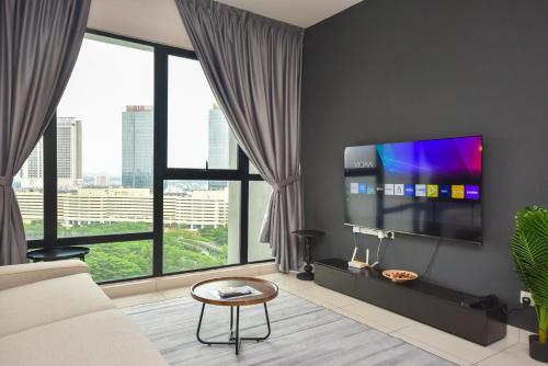 a living room with a flat screen tv and large windows at Midvalley Southkey Mosaic Suite by Nest Home in Johor Bahru