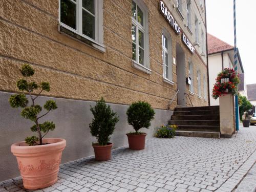a brick building with potted plants in front of it at Gasthof Klement in Isen