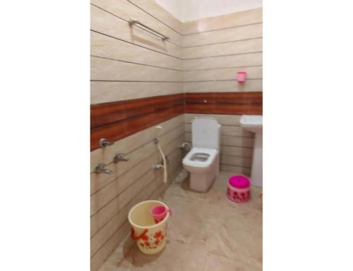 Un baño con inodoro y cubos dentro. en Vaishnavi Shakti Peeth, Vrindavan, en Vrindāvan