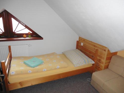 a small bed in a room with a window at Jako doma in Albrechtice v Jizerských horách