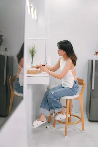 a woman sitting on a chair at a table in a kitchen at La Casa 1101 in Amoloñgin