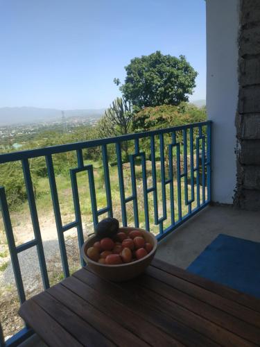 a bowl of fruit sitting on a table on a balcony at Room With Balcony In Family Farm House UK Host in Arusha