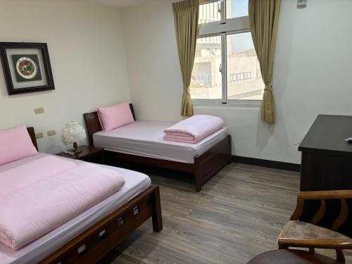 a room with two beds and a window at 今友緣二館民宿 in Dongyin