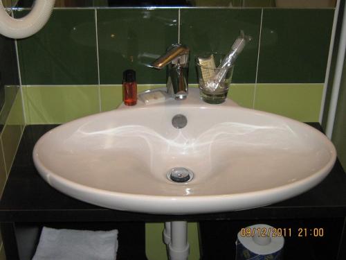 a white sink with a glass on top of it at Hotel Mosca in Monza