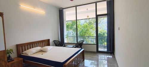 a bedroom with a bed and a large window at GMSquare in Thekkady