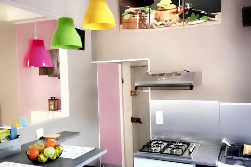 a kitchen with a stove and some colorful lights at Studio chaleureux à Puget-Théniers, 27 m² avec vue montagne in Puget-Théniers