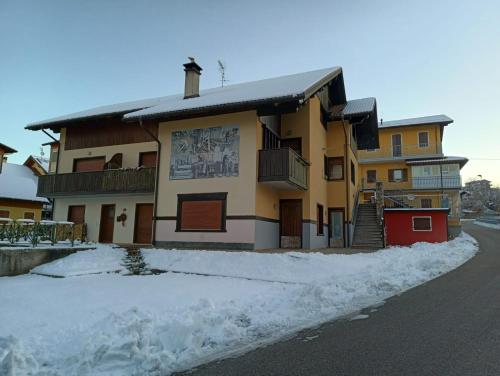a building with snow on the side of a street at Casa Alpago in Spert