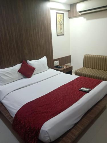 a bedroom with a large bed and a couch at Hotel Asian Inn, Nagpur in Nagpur