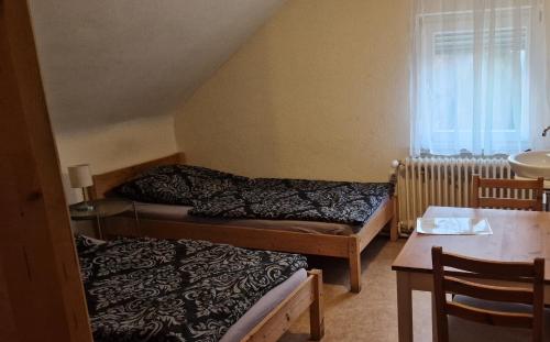a small room with two beds and a table at Monteurpension Haus Monika in Marktheidenfeld