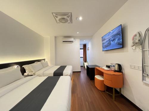a hotel room with two beds and a desk at Asia Premium Hotel Kuala Terengganu in Kuala Terengganu