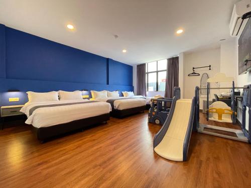 a bedroom with three beds and a slide at Asia Premium Hotel Kuala Terengganu in Kuala Terengganu