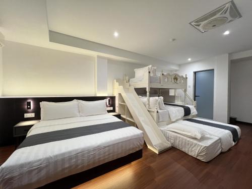 two beds in a room with two bunk beds at Asia Premium Hotel Kuala Terengganu in Kuala Terengganu