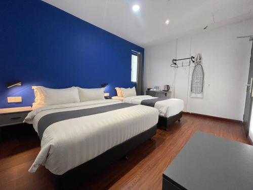 two beds in a room with a blue wall at Asia Premium Hotel Kuala Terengganu in Kuala Terengganu