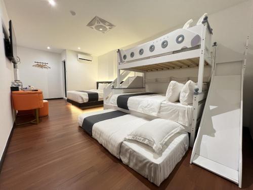 a bedroom with two bunk beds and a television at Asia Premium Hotel Kuala Terengganu in Kuala Terengganu