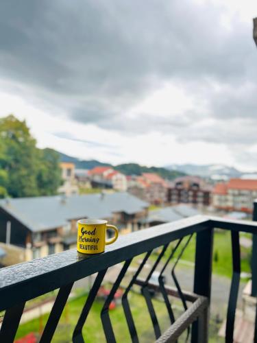 a yellow coffee cup sitting on a bench with a view at Rest in Bakuriani in Bakuriani