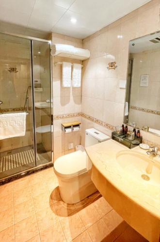 a bathroom with a toilet and a shower and a sink at 福禄寿酒店 in Beiwusidui