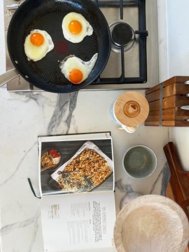 a frying pan with eggs and a book on a counter at Hilltop Haven Darlington in Darlington