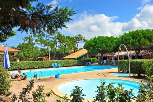 un homme est assis à côté d'une piscine dans l'établissement VTF La Forestière, à Lacanau-Océan