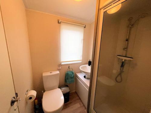a bathroom with a toilet and a sink and a shower at Pass the Keys Cosy Welcoming 3BR in Beautiful Country Park in Beattock